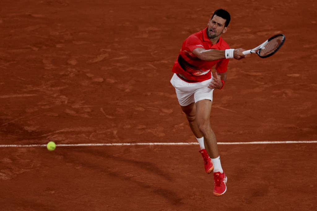 Serbia's Novak Djokovic returns the ball to Japan's Yoshihito Nishioka during their men's singles match on day two of the Roland-Garros Open tennis tournament at the Court Philippe-Chatrier in Paris on May 23, 2022. (Photo by Thomas SAMSON / AFP)