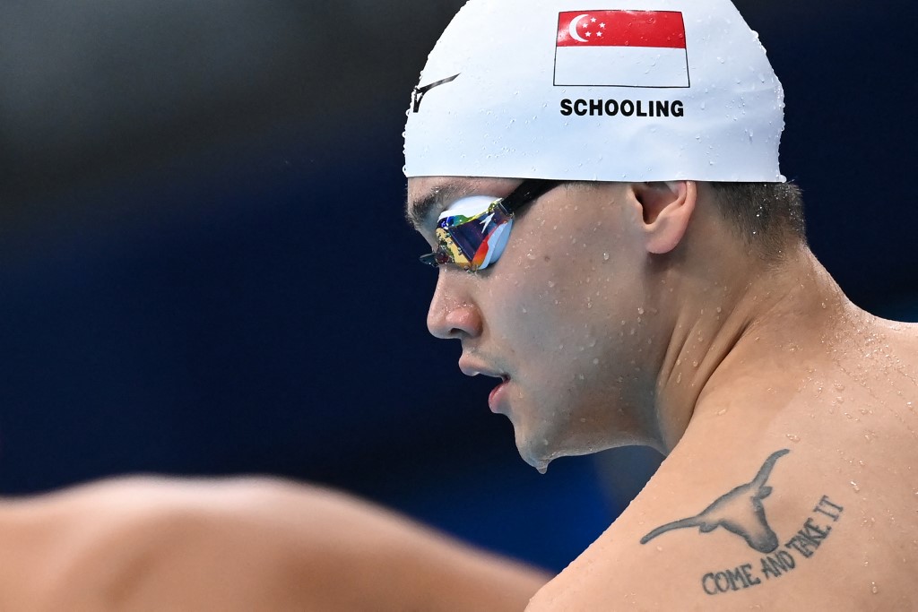 A tattoo is seen on the back of Singapore's Joseph Schooling as he prepares to compete in a heat for the men's 100m freestyle swimming event during the Tokyo 2020 Olympic Games at the Tokyo Aquatics Centre in Tokyo on July 27, 2021.