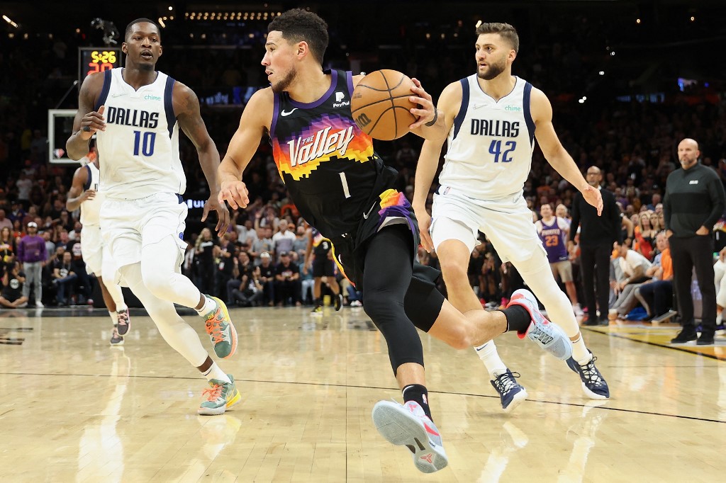 Devin Booker #1 of the Phoenix Suns drives the ball past Dorian Finney-Smith #10 and Maxi Kleber #42 of the Dallas Mavericks during the second half of Game Five of the Western Conference Second Round NBA Playoffs at Footprint Center on May 10, 2022 in Phoenix, Arizona. The Suns 