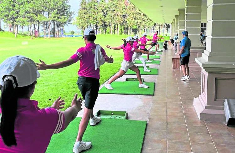 Members of the Philippine golf team warm up before training.