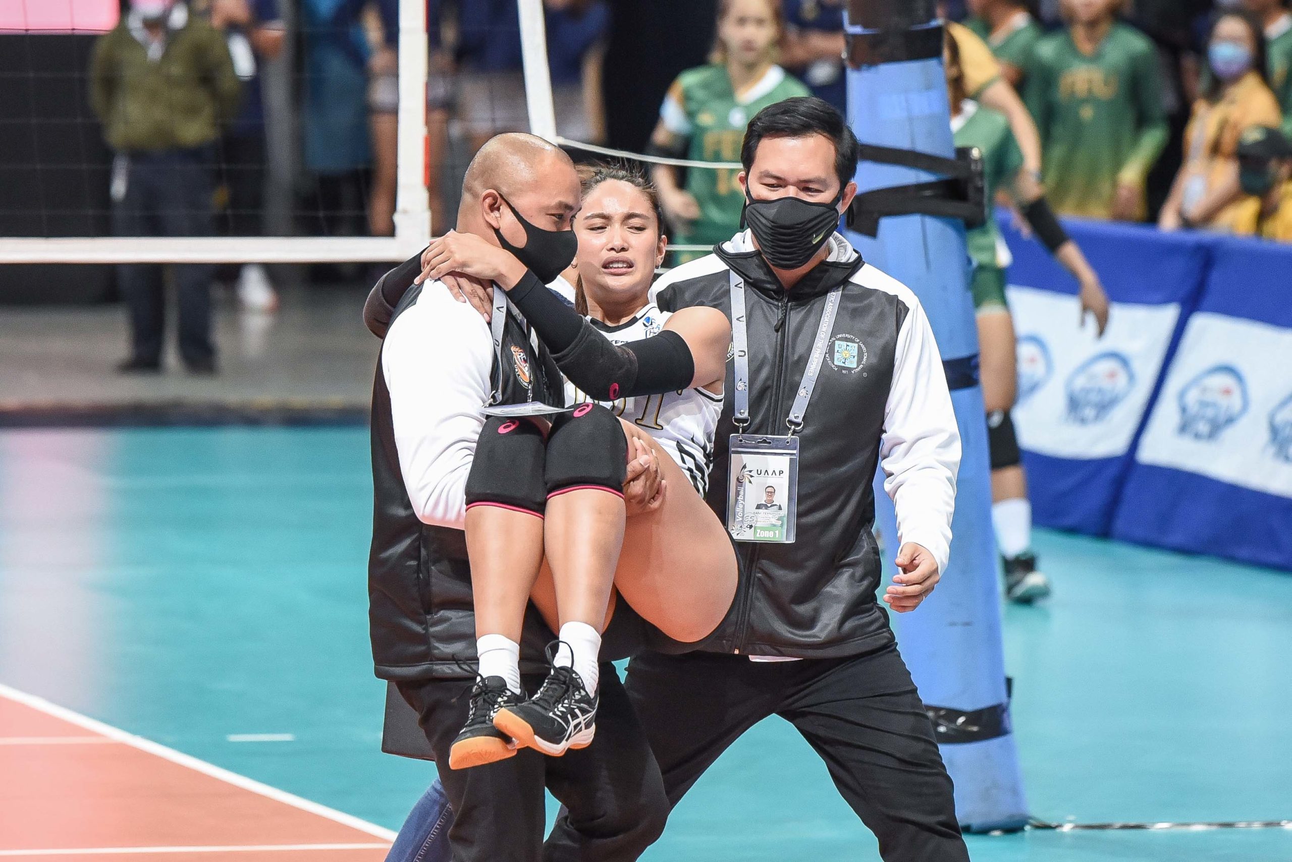 Imee Hernandez being carried by UST coach KungFu  Reyes after injuring ankle. UAAP PHOTO
