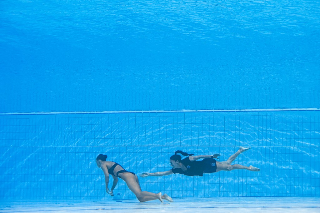 ABD (R) Takımı'nın bir üyesi, Budapeşte'deki Alfred Hajos yüzme kompleksinde Budapeşte 2022 Dünya Su Sporları Şampiyonası sırasında bayanlar solo serbest yüzme finalinde bir kaza sırasında ABD'li Anita Alvarez'i (solda) havuzun altından alıyor Haziran 22 2022.