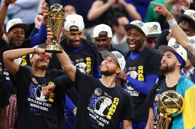 Stephen Curry of the Golden State Warriors raises the Bill Russell NBA Finals Most Valuable Player Award after defeating the Boston Celtics 103-90 in Game Six of the 2022 NBA Finals at TD Garden on June 16, 2022 in Boston, Massachusetts.  