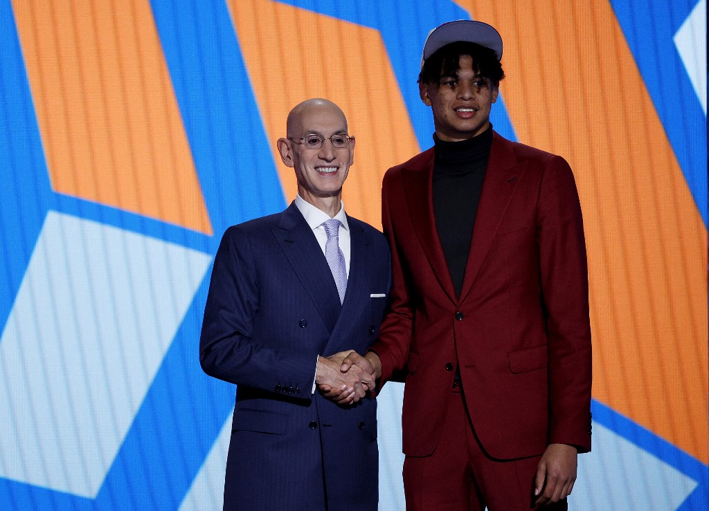    NBA Komiseri Adam Silver (solda) ve Ousmane Dieng, Dieng'in Haziran ayında Barclays Center'da düzenlenen 2022 NBA Seçmeleri sırasında New York Knicks tarafından 11. sıradan seçilmesinin ardından fotoğraflar için poz veriyor. 