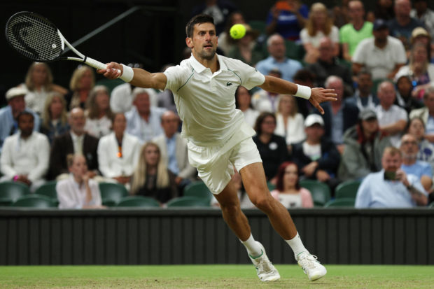 Serbia's Novak Djokovic returns the ball to Netherlands' Tim van Rijthoven during their round of 16 men's singles tennis match on the seventh day of the 2022 Wimbledon Championships at The All England Tennis Club in Wimbledon, southwest London, on July 3, 2022. (Photo by Adrian DENNIS / AFP) / RESTRICTED TO EDITORIAL USE