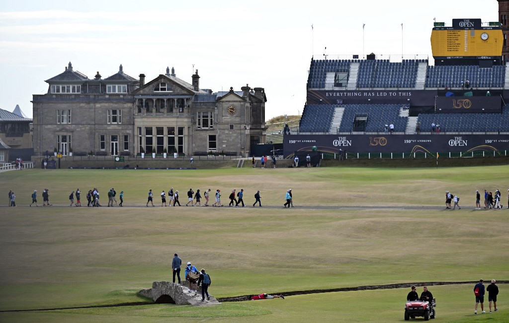 Northern Ireland's Rory McIlroy walks across the Swilcan Bridge on the 18th fairway during a practice round for The 150th British Open Golf Championship on The Old Course at St Andrews in Scotland on July 13, 2022