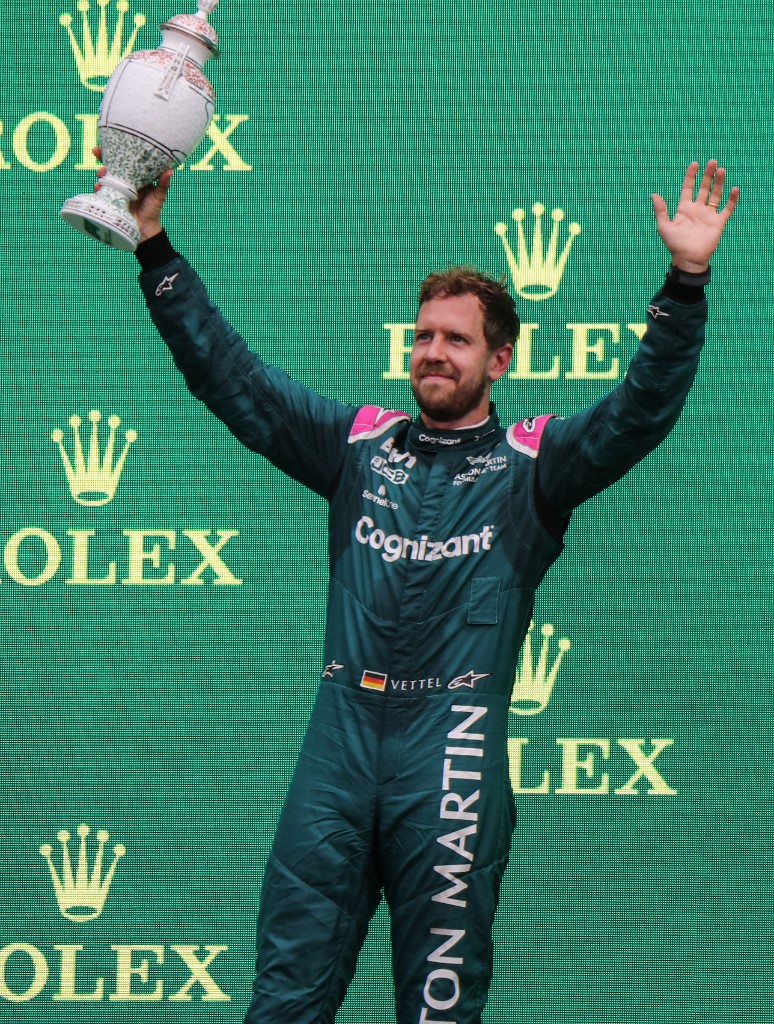 Aston Martin's German driver Sebastian Vettel celebrates with the trophy on the podium after the Formula One Hungarian Grand Prix at the Hungaroring race track in Mogyorod near Budapest on August 1, 2021. 