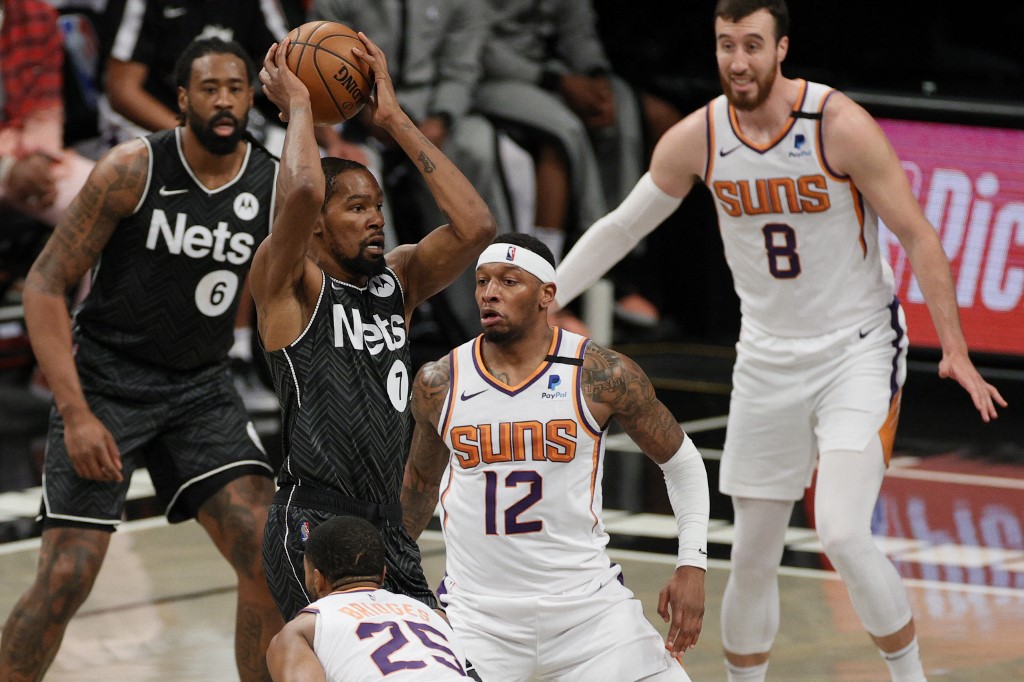  Kevin Durant #7 of the Brooklyn Nets looks to pass as Torrey Craig #12 and Mikal Bridges #25 of the Phoenix Suns