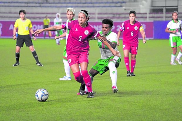 Defender Hali Long (No. 5) of the Philippines was pulled out of position by Indonesian striker Selly Wunungga.  —PICTURES OF EMPLOYEES