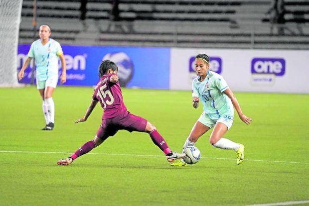 Philippines centre-back Quinley Quezada (right) tries to move past Thailand's Orapin Waenngoen.  —PICTURES OF EMPLOYEES