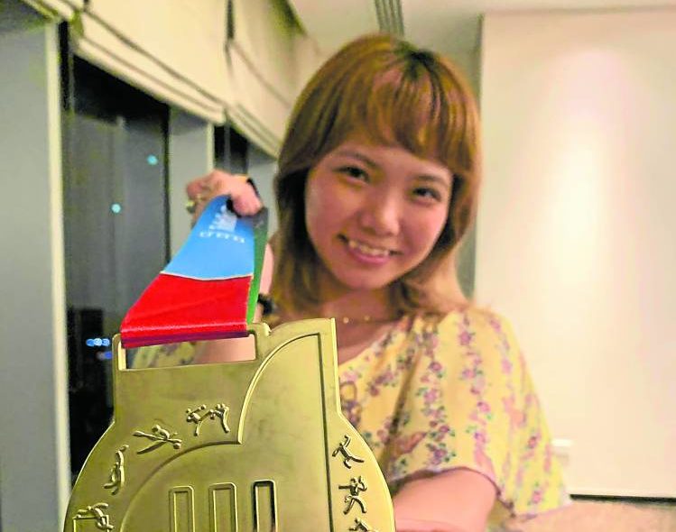 Junna Tsukii viser frem gullmedaljen hun vant på verdenslekene.  —JUNI NAVARRA