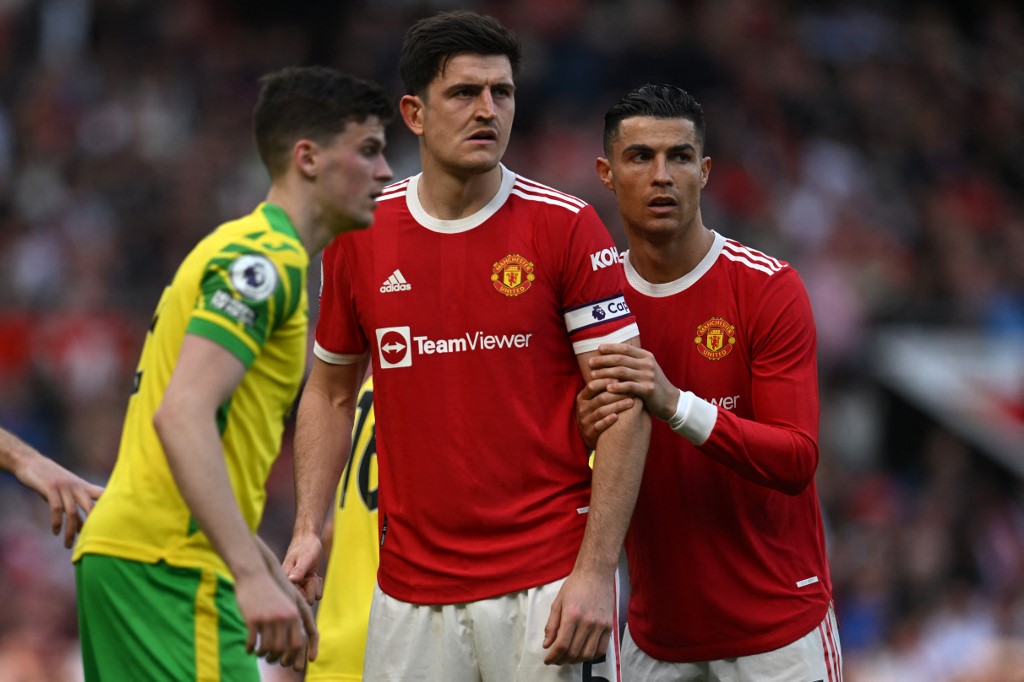 Manchester United's Portuguese striker Cristiano Ronaldo (R) and Manchester United's English defender Harry Maguire (C) wait for the ball to be delivered during the English Premier League football match between Manchester United and Norwich City at Old Trafford in Manchester, north west England, on April 16, 2022. 