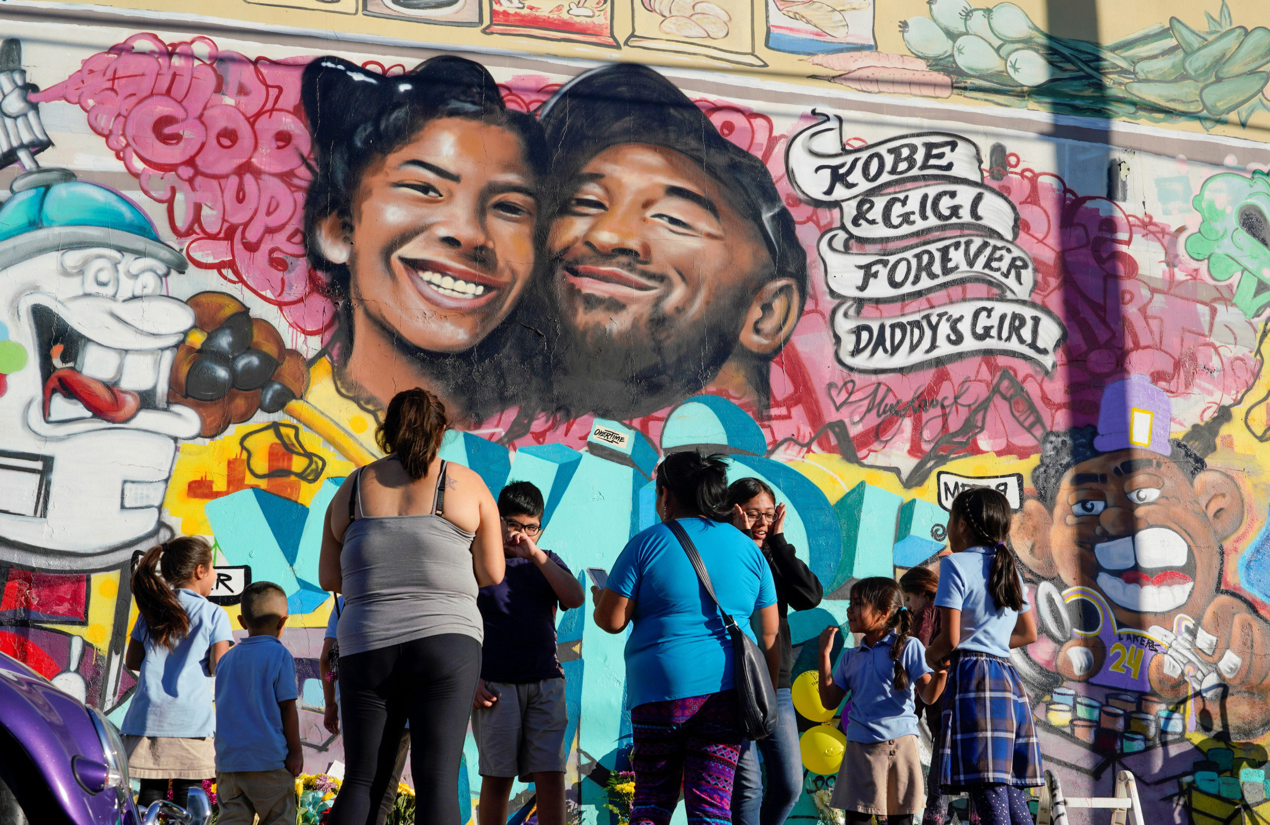 FILE PHOTO: Fans gather around a mural to pay respects to Kobe Bryant after a helicopter crash killed the retired basketball star, in Los Angeles, California, U.S., January 28, 2020.  