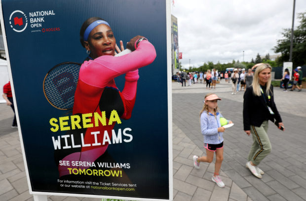 People pass a poster advertising the match of veteran tennis player Serena Williams, who said that she plans to retire after the 2022 U.S. Open, outside a stadium at the National Bank Open in Toronto, Ontario, Canada August 9, 2022. REUTERS/Chris Helgren