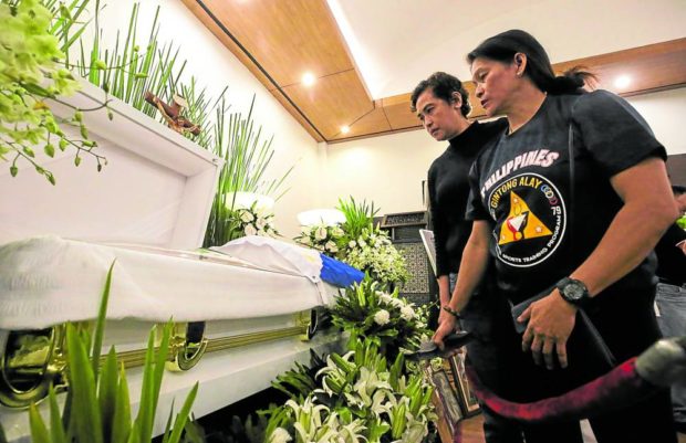 Ex-national volleyball player Mary Jane Santos (left) and former SEAG long jump queen Elma Muros-Posadas pay their last respects to Lydia de Vega during the late track great’s wake at Heritage Memorial Park in Taguig. De Vega, who died on Wednesday last week, will be laid to rest in her native Meycauayan, Bulacan. —LYN RILLON