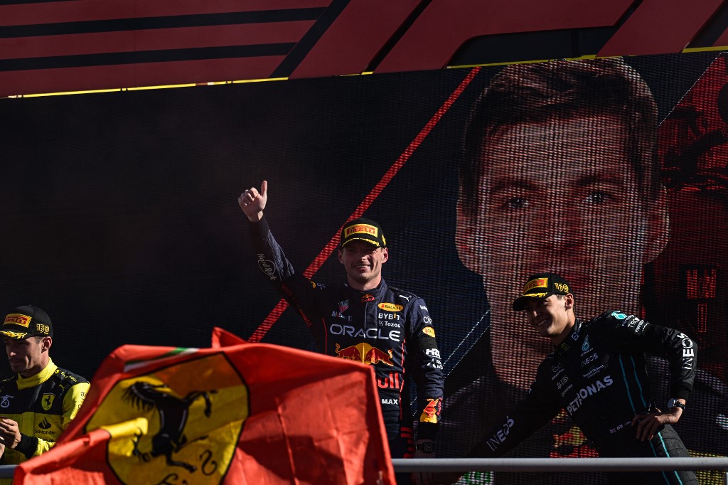Winner Red Bull Racing's Dutch driver Max Verstappen (C) celebrates with second-placed Ferrari's Monegasque driver Charles Leclerc (L) and third-placed Mercedes' British driver George Russell (R) on the podium after the Italian Formula One Grand Prix at the Autodromo Nazionale circuit in Monza on September 11, 2022. 