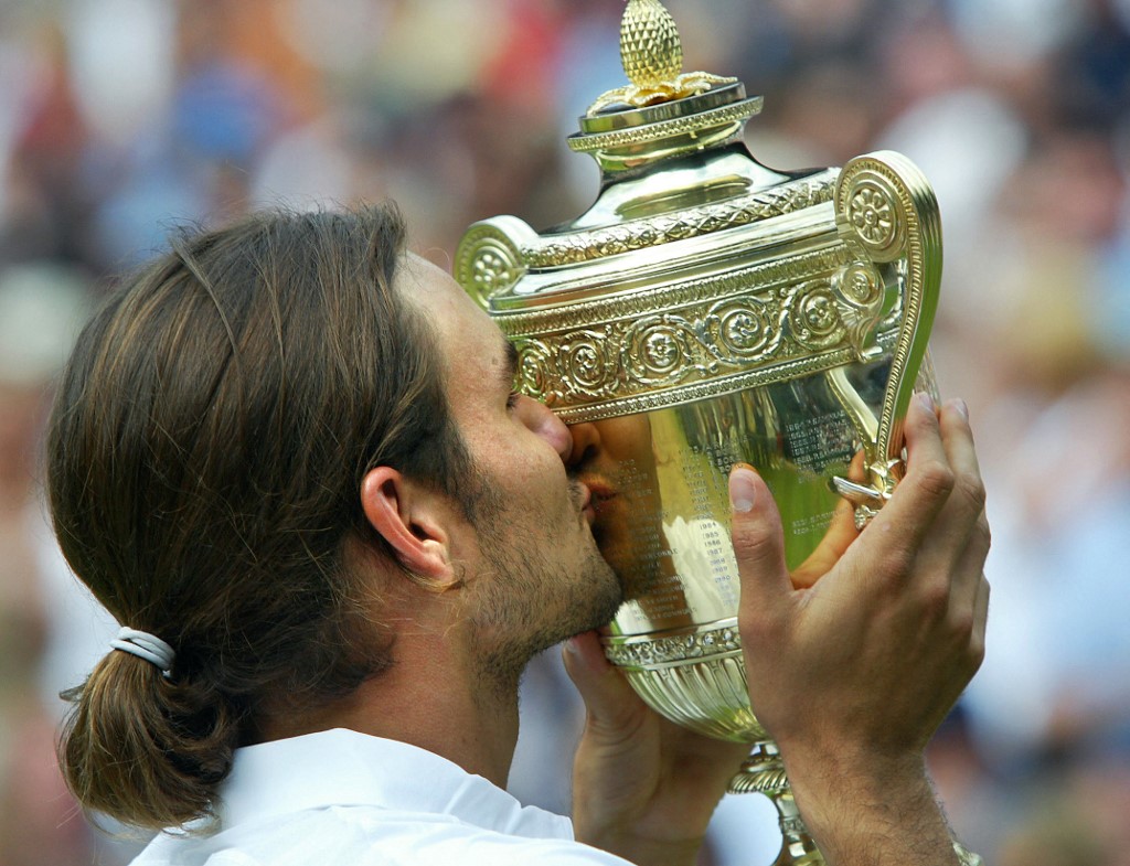 (FILES) In this file photo taken on July 6, 2003 Roger Federer of Switzerland kisses the Wimbledon trophy after defeating Mark Philippoussis of Australia in their Men's Final match at the Wimbledon Tennis Championships in Wimbledon, south London. - Swiss tennis legend Roger Federer is to retire after next week's Laver Cup, he said on September 15, 2022. 