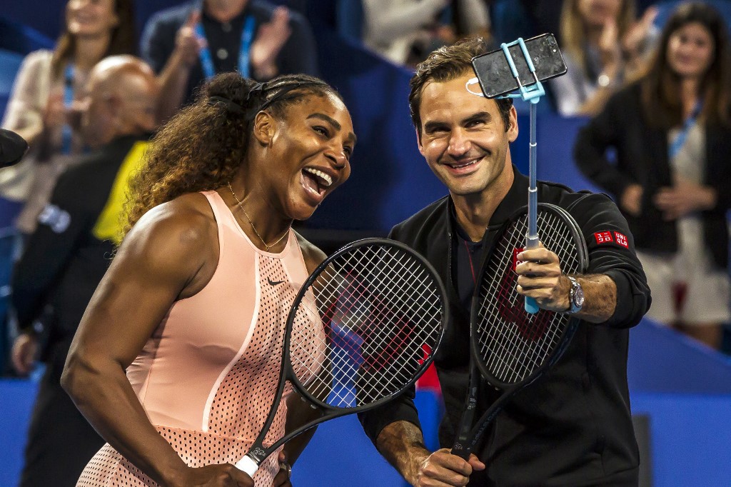(FILES) In this file photo taken on January 1, 2019 Serena Williams of the US (L) and Roger Federer of Switzerland (R) take a selfie following their mixed doubles match on day four of the Hopman Cup tennis tournament in Perth