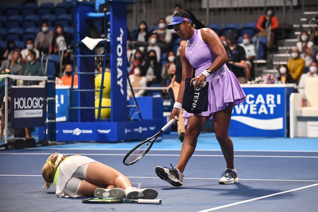 Naomi Osaka of Japan (R) assists Daria Saville of Australia after she injured herself during their women's singles match on day two of the Pan Pacific Open tennis tournament in Tokyo on September 20, 2022. (