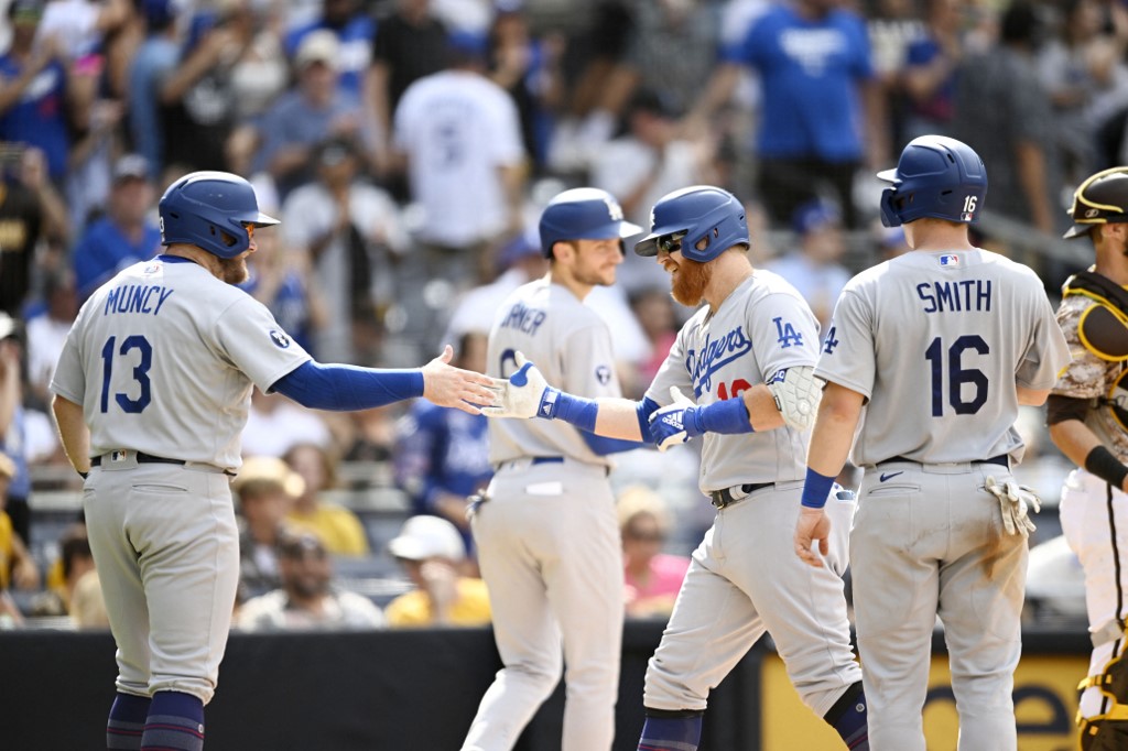 Justin Turner #10 of the Los Angeles Dodgers (R) is congratulated by Max Muncy #13 after he hit a grand slam during the seventh inning of a baseball game against the San Diego Padres September 11, 2022 at Petco Park in San Diego, California. 