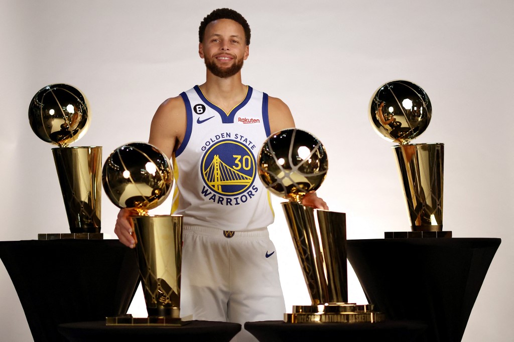 Stephen Curry #30 of the Golden State Warriors poses with the four Larry O'Brien Championship Trophies that he has won with the Warriors during the Warriors Media Day on September 25, 2022 in San Francisco, California.