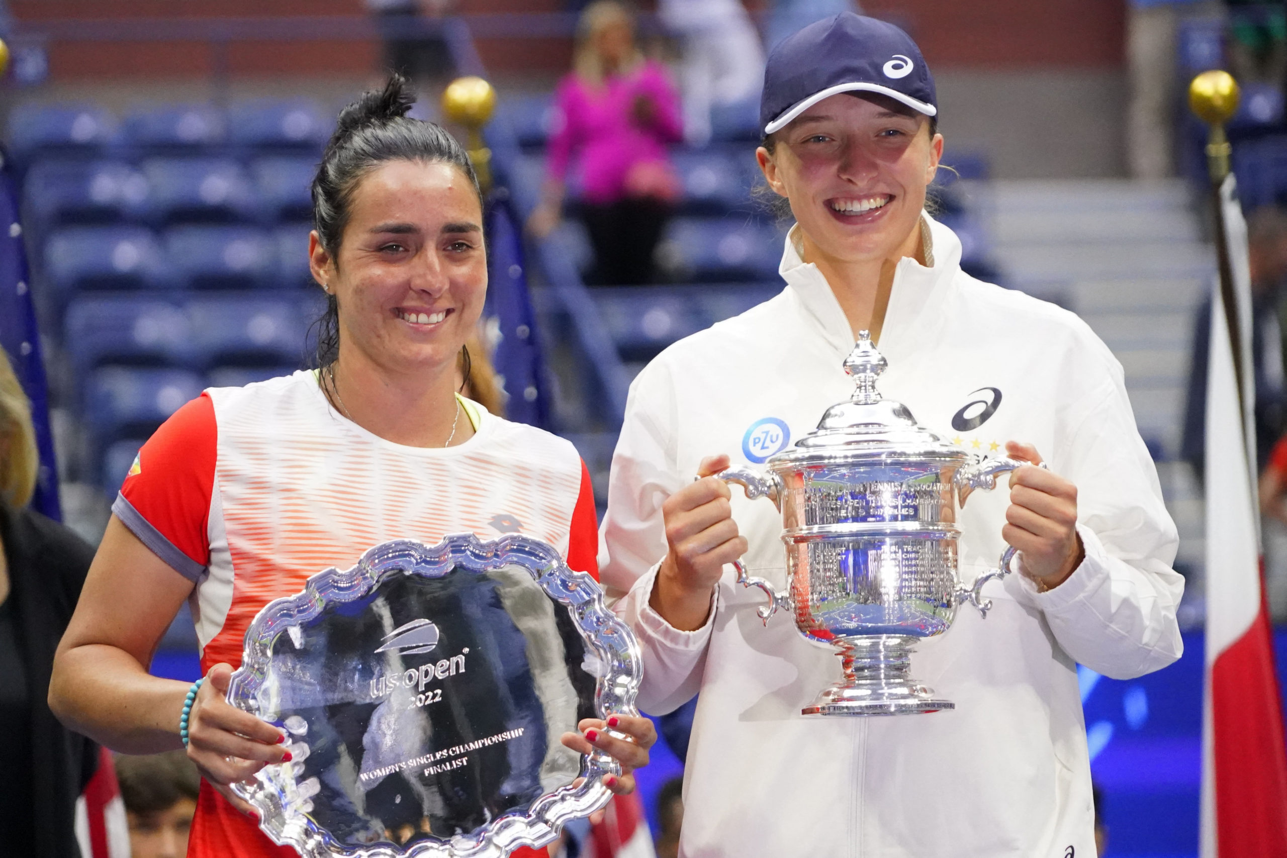 Ons Jabeur (TUN) (L) and Iga Swiatek (POL) (R) hold the finalist and championship trophies (respectively) after their match in the women's singles final on day thirteen of the 2022 U.S. Open tennis tournament at USTA Billie Jean King Tennis Center