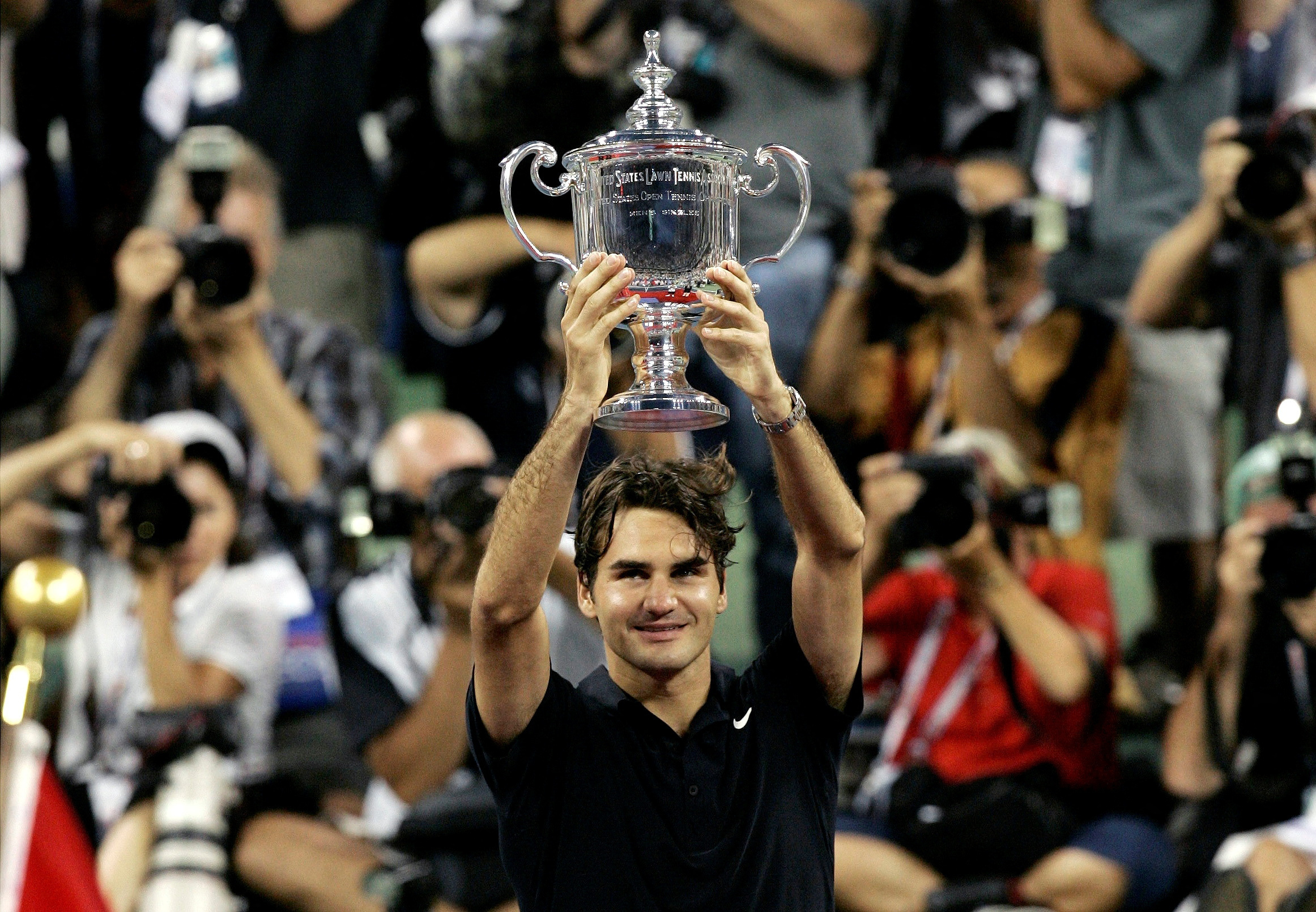 FILE PHOTO: Roger Federer of Switzerland holds up the trophy in front of photographers after winning his match against Novak Djokovic of Serbia in the men's final of the U.S. Open tennis tournament in Flushing Meadows, New York, September 9, 2007.