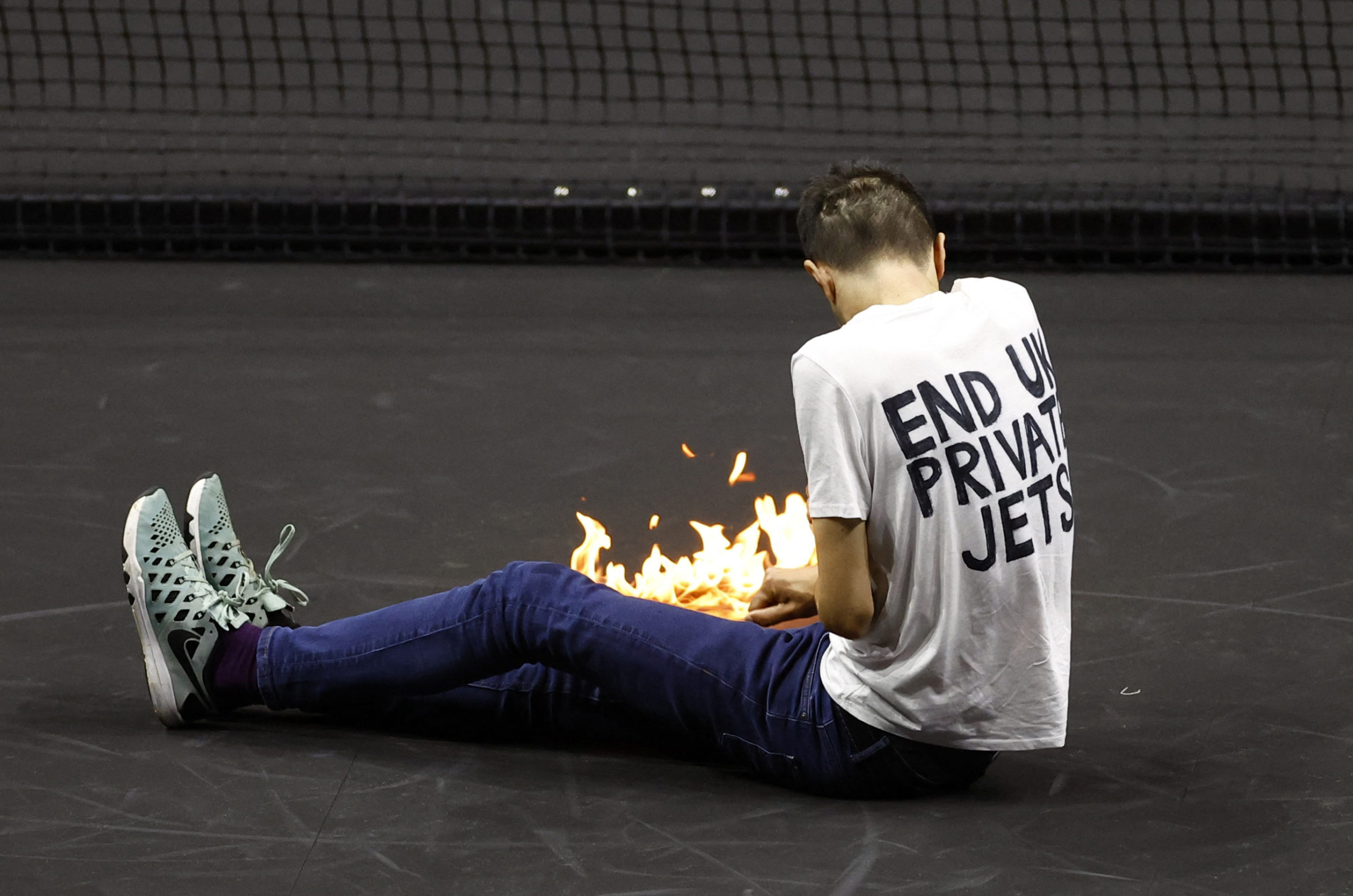 Tennis - Laver Cup - 02 Arena, London, Britain - September 23, 2022   A protester lights a fire on the court during the match between Team Europe's Stefanos Tsitsipas and Team World's Diego Schwartzman 