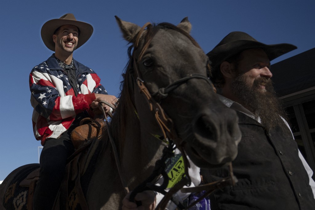McLaren's Australian driver Daniel Ricciardo arrives in the paddock on horseback during the Formula One United States Grand Prix preview day, at the Circuit of the Americas in Austin, Texas, on October 20, 2022.