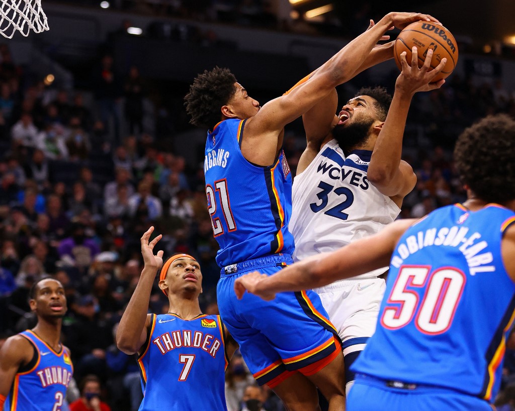  Karl-Anthony Towns #32 of the Minnesota Timberwolves drives to the basket against Aaron Wiggins #21 of the Oklahoma City Thunder in the third quarter at Target Center on January 5, 2022 in Minneapolis, Minnesota.