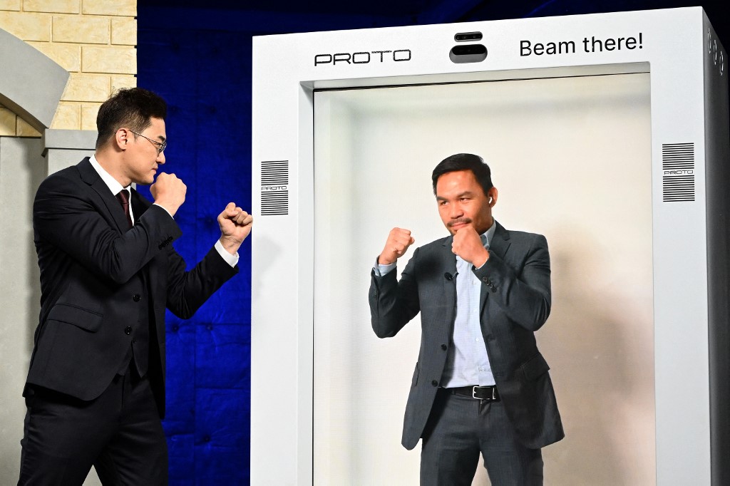 DK Yoo (L) faces off with Manny Pacquiao who appeared in a hologram during a press conference on October 13, 2022 in Van Nuys, California.  