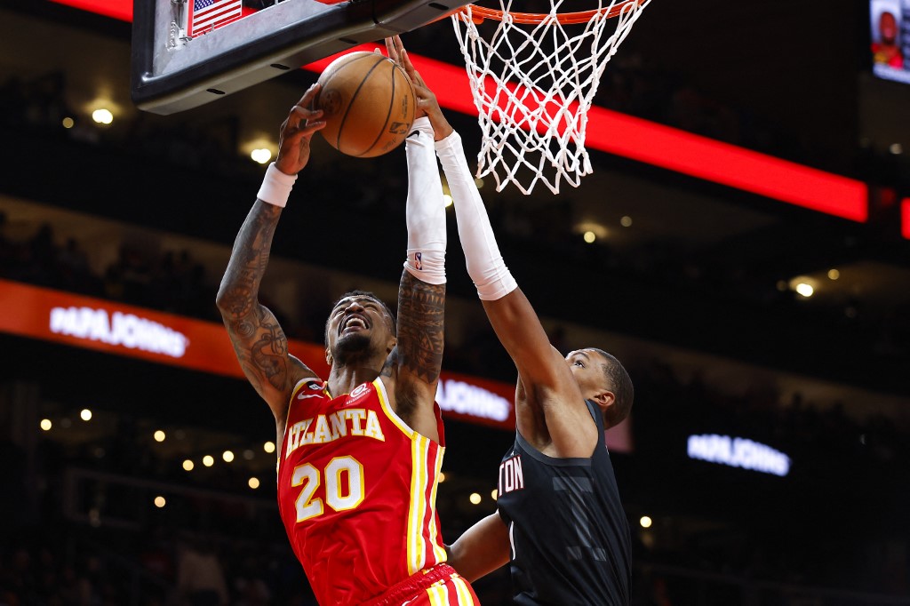 John Collins #20 of the Atlanta Hawks drives to the basket against Jabari Smith Jr. #1 of the Houston Rockets during the second half at State Farm Arena on October 19, 2022 in Atlanta, Georgia.