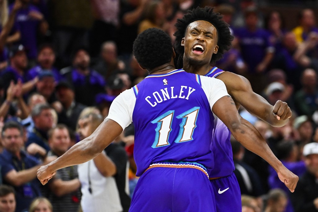 Mike Conley #11 and Collin Sexton #2 of the Utah Jazz celebrate a play against the Denver Nuggets at Vivint Arena on October 19, 2022 in Salt Lake City, Utah. 