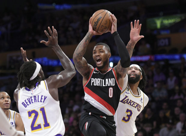 Damian Lillard #0 of the Portland Trail Blazers looks to pass the ball under pressure from Patrick Beverley #21 and Anthony Davis #3 of the Los Angeles Lakers during the first half of the game at Crypto.com Arena on October 23, 2022 in Los Angeles, California. NOTE TO USER: User expressly acknowledges and agrees that, by downloading and/or using this Photograph, user is consenting to the terms and conditions of the Getty Images License Agreement.   Kevork Djansezian/Getty Images/AFP (Photo by KEVORK DJANSEZIAN / GETTY IMAGES NORTH AMERICA / Getty Images via AFP)