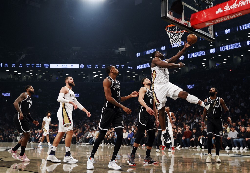 Zion Williamson #1 of the New Orleans Pelicans goes to the basket as Nic Claxton #33 and Ben Simmons #10 of the Brooklyn Nets defend during the first half at Barclays Center on October 19, 2022 in the Brooklyn borough of New York City. 