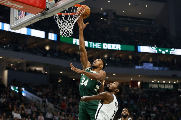 Giannis Antetokounmpo #34 of the Milwaukee Bucks scores over Kevin Durant #7 of the Brooklyn Nets during the first half of the game at Fiserv Forum on October 26, 2022 in Milwaukee, Wisconsin. NOTE TO USER: User expressly acknowledges and agrees that, by downloading and or using this photograph, User is consenting to the terms and conditions of the Getty Images License Agreement.   John Fisher/Getty Images/AFP (Photo by John Fisher / GETTY IMAGES NORTH AMERICA / Getty Images via AFP)