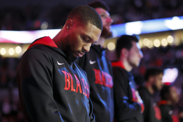 Oct 26, 2022; Portland, Oregon, USA; Portland Trail Blazers point guard Damian Lillard (0) stands during the national anthem before the game  against the Miami Heat  at Moda Center.