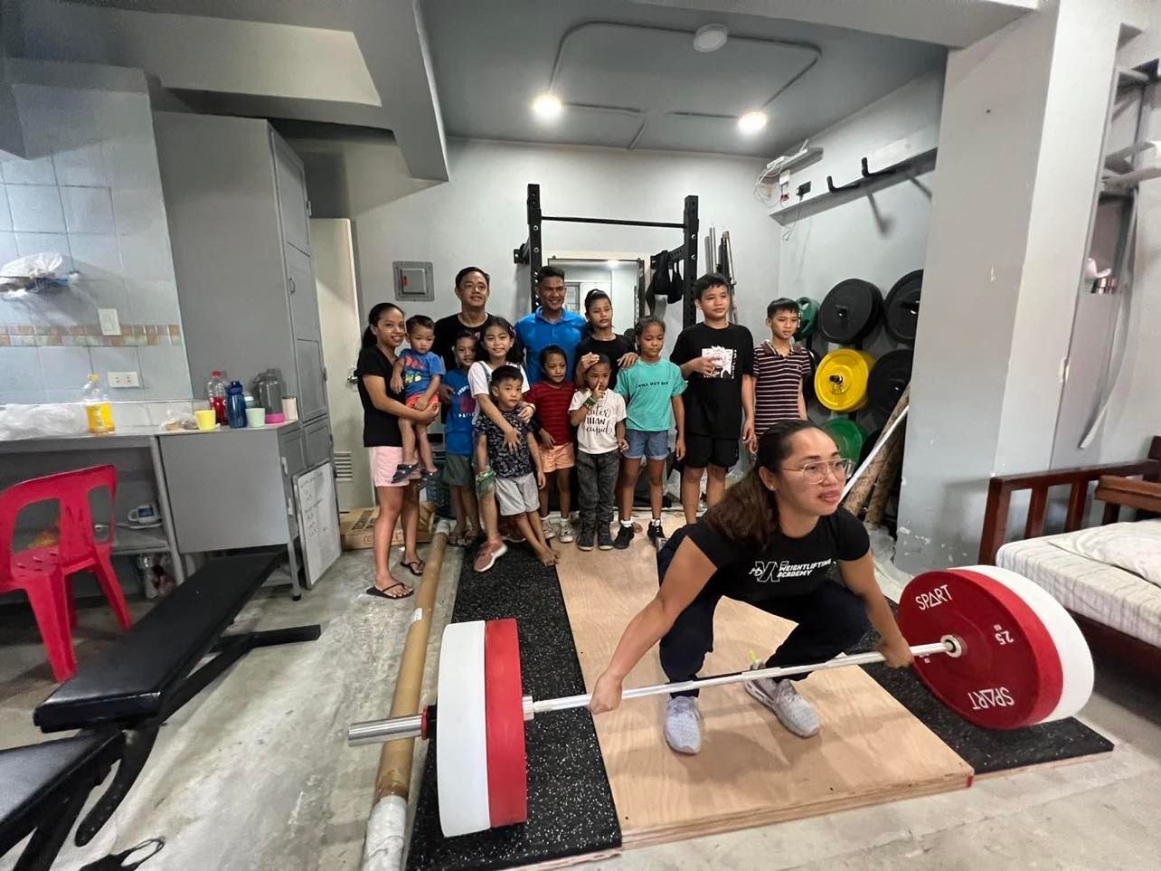 Tokyo Olympics gold medalist Hidilyn Diaz shows her lifting form during a weightlifting equipment donation at Manila Weightlifting Club in Tondo, Manila