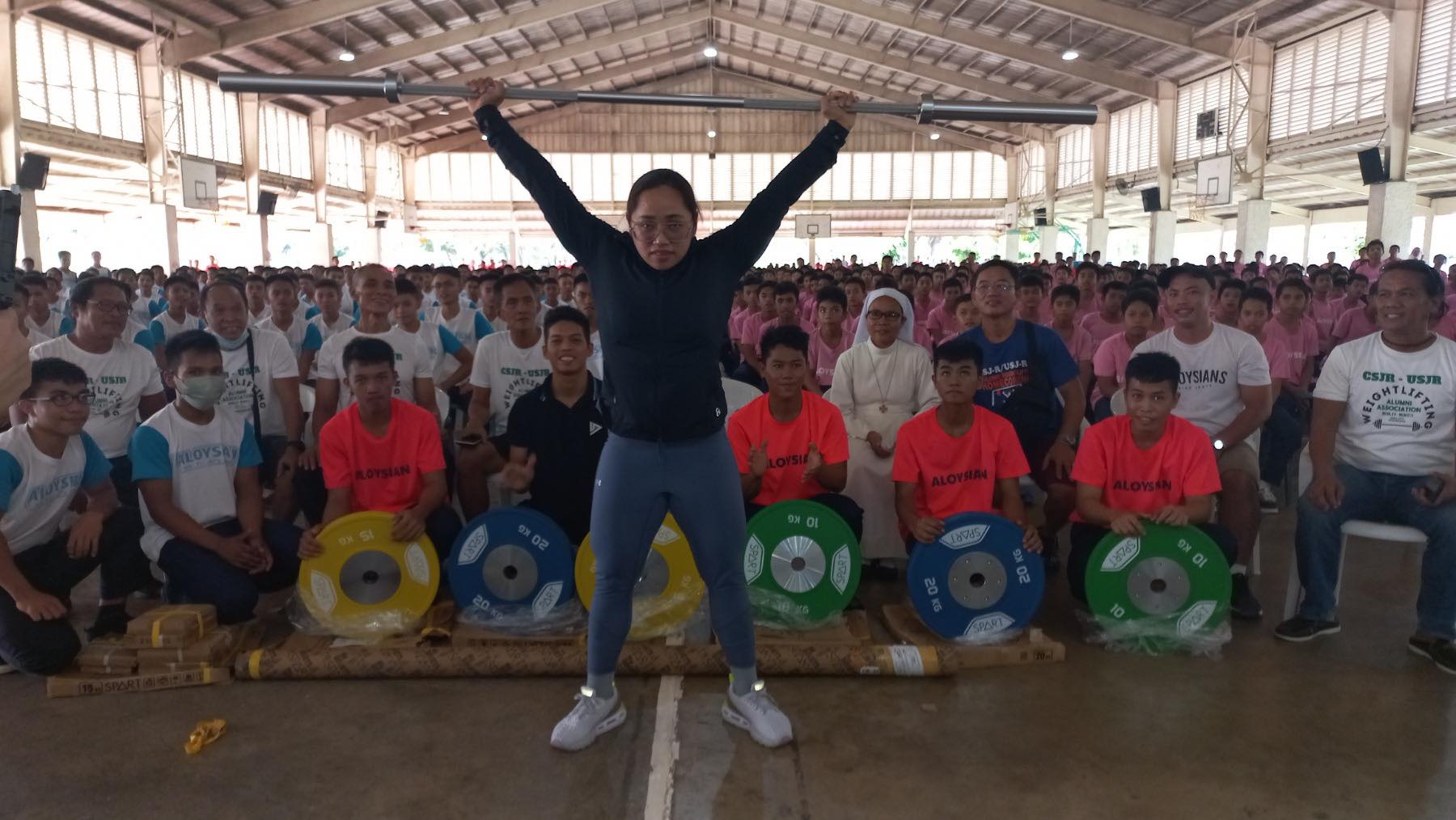 Tokyo Olympics gold medalist Hidilyn Diaz shows her lifting form during a weightlifting equipment donation at the Sisters of Mary Boys Town in Talisay, Cebu. 