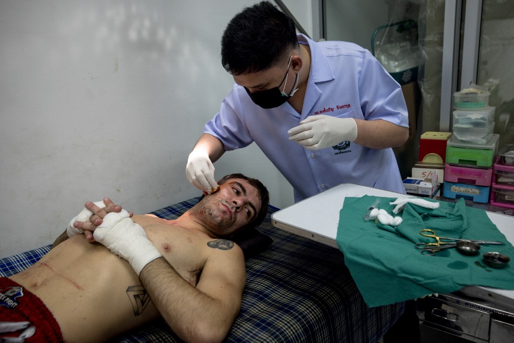 In this photo taken on September 24, 2022, Argentinian Muay Thai boxer Federico Vernengo (L) is treated by medic Phongcharoen Ungkharjornkul (R) after being defeated by technical knockout in his fight at Lumpinee Stadium in Bangkok.