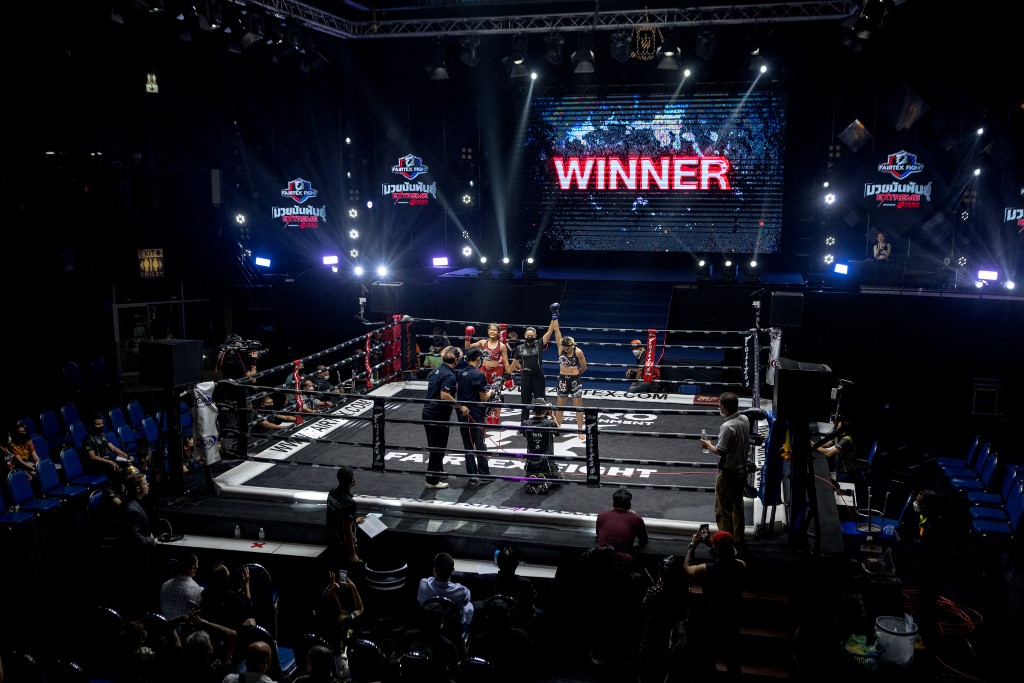In this photo taken on September 24, 2022, Muay Thai boxers Sahar Safari (centre R) from Iran is declared winner after her fight with Dueannapha Sor. Kaenchanchai from Thailand (centre L) at Lumpinee Stadium in Bangkok. -