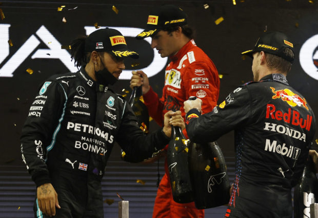 FILE PHOTO: Formula One F1 - Abu Dhabi Grand Prix - Yas Marina Circuit, Abu Dhabi, United Arab Emirates - December 12, 2021 Mercedes' Lewis Hamilton after finishing second in the race and world championship with race and world championship winner Red Bull's Max Verstappen and third placed in the race Ferrari's Carlos Sainz Jr. 