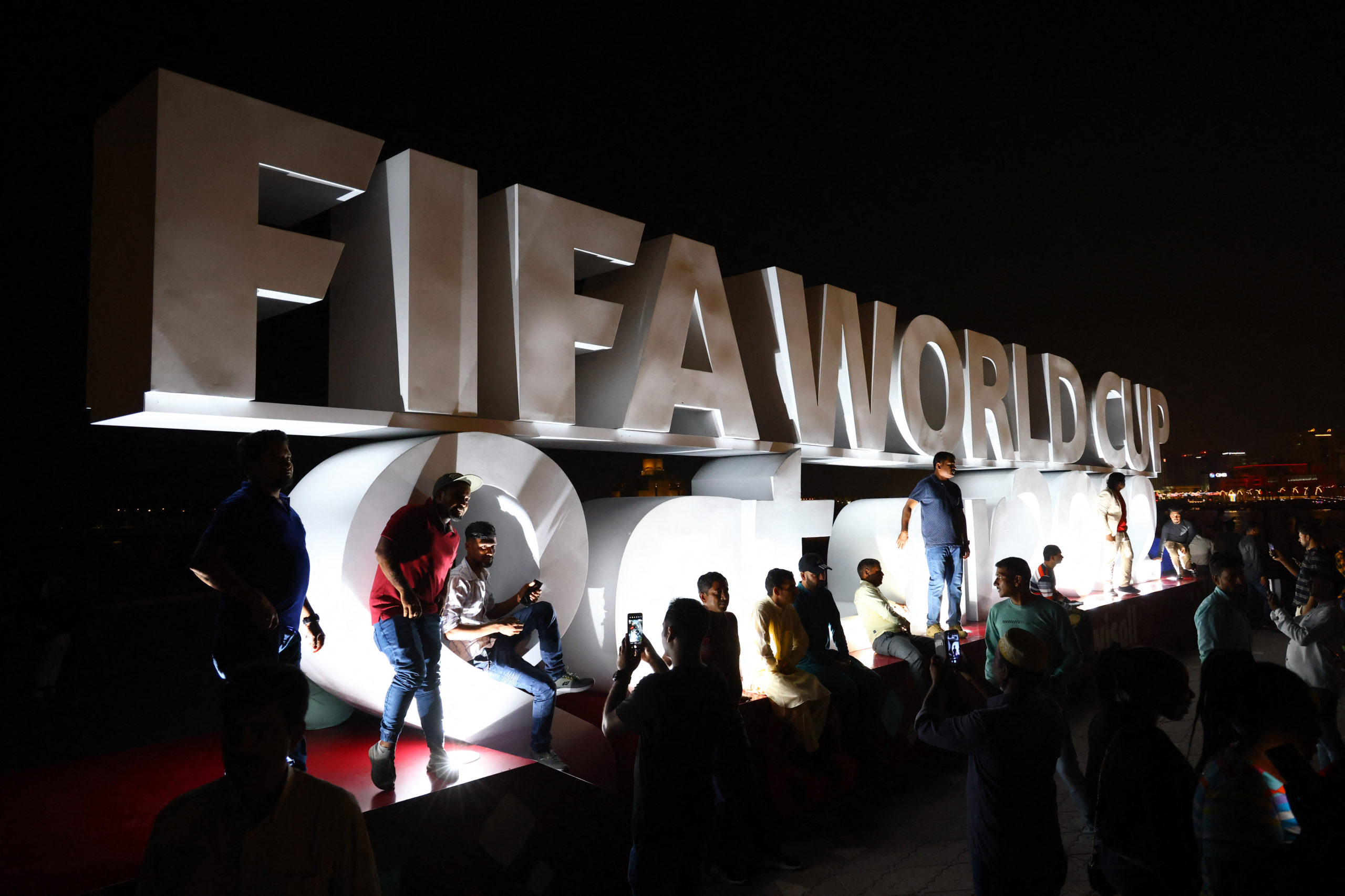 FILE PHOTO: Soccer Football - FIFA World Cup Qatar 2022 Preview, Doha, Qatar - November 18, 2022  Fans take pictures with the FIFA World Cup logo on the Corniche Promenade ahead of the FIFA World Cup Qatar 2022 