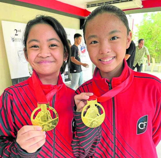 Willa Liana Galvez (right) and Nicol Amethyst Canlas show off their gold medals. 
