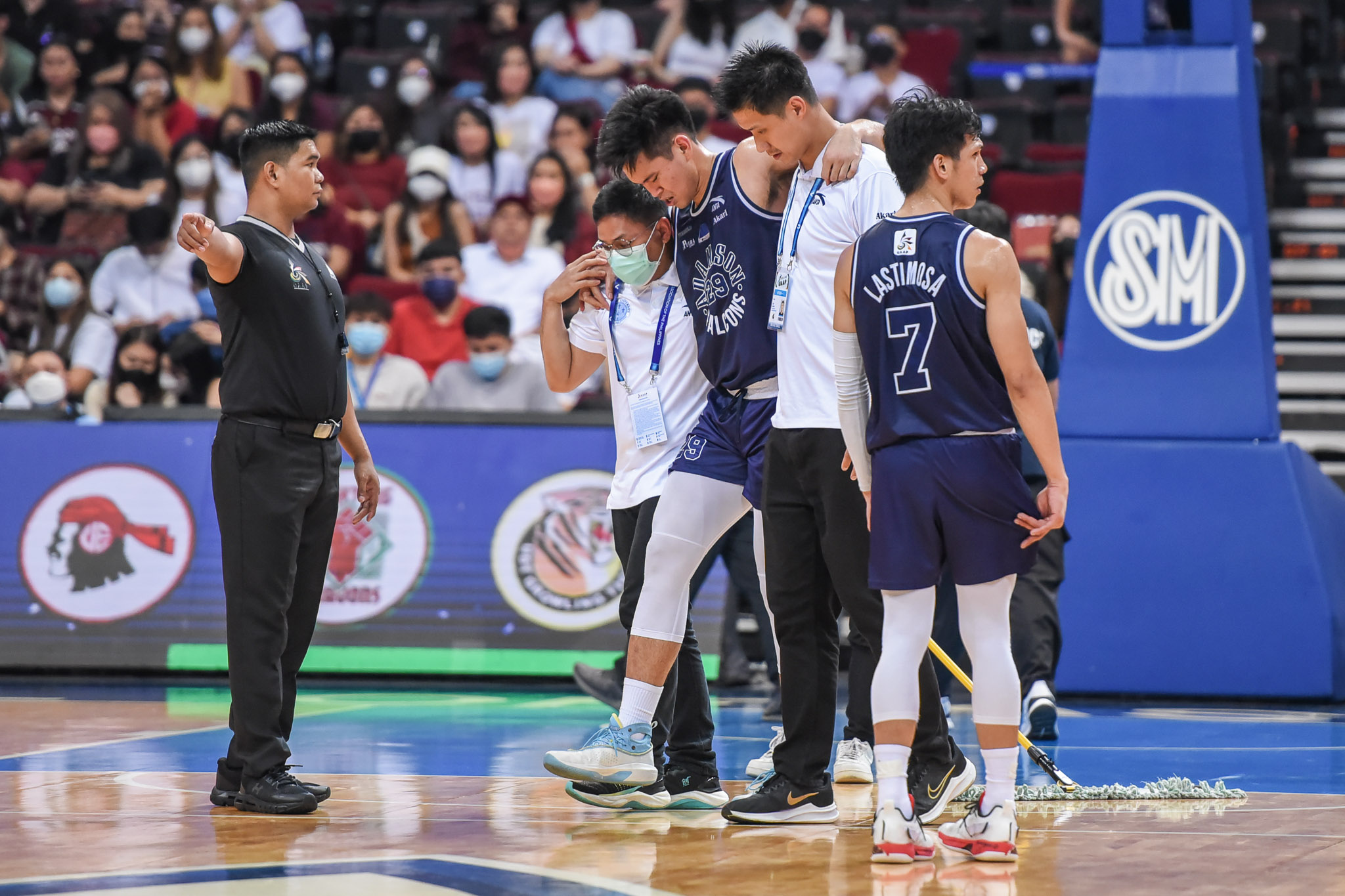 Adamson's Vince Magbuhos helped off the court after injuring his right knee. -UAAP PHOTO