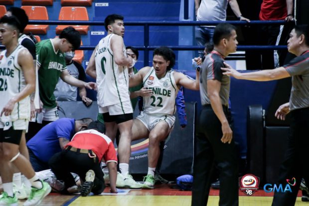 St. Benilde Blazers' Taine Davis staggers after taking a punch from John Amores. –NCAA PHOTO