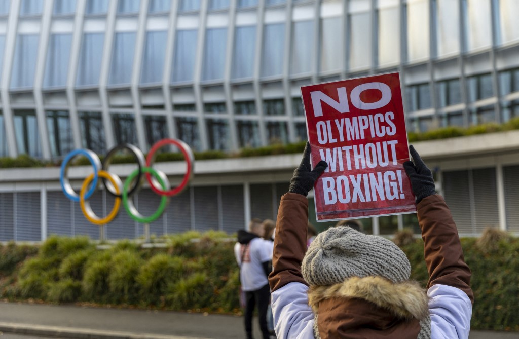 A woman holds a poster in support of boxing at the Olympics Games on the sidelines of the Executive Board meeting, in front of the Olympic House, in Lausanne, Switzerland, on December 5, 2022.