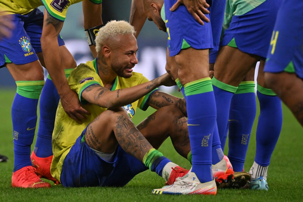 Brazil's forward #10 Neymar is consoled by teammates after they lost the Qatar 2022 World Cup quarter-final football match between Croatia and Brazil at Education City Stadium in Al-Rayyan, west of Doha, on December 9, 2022. 