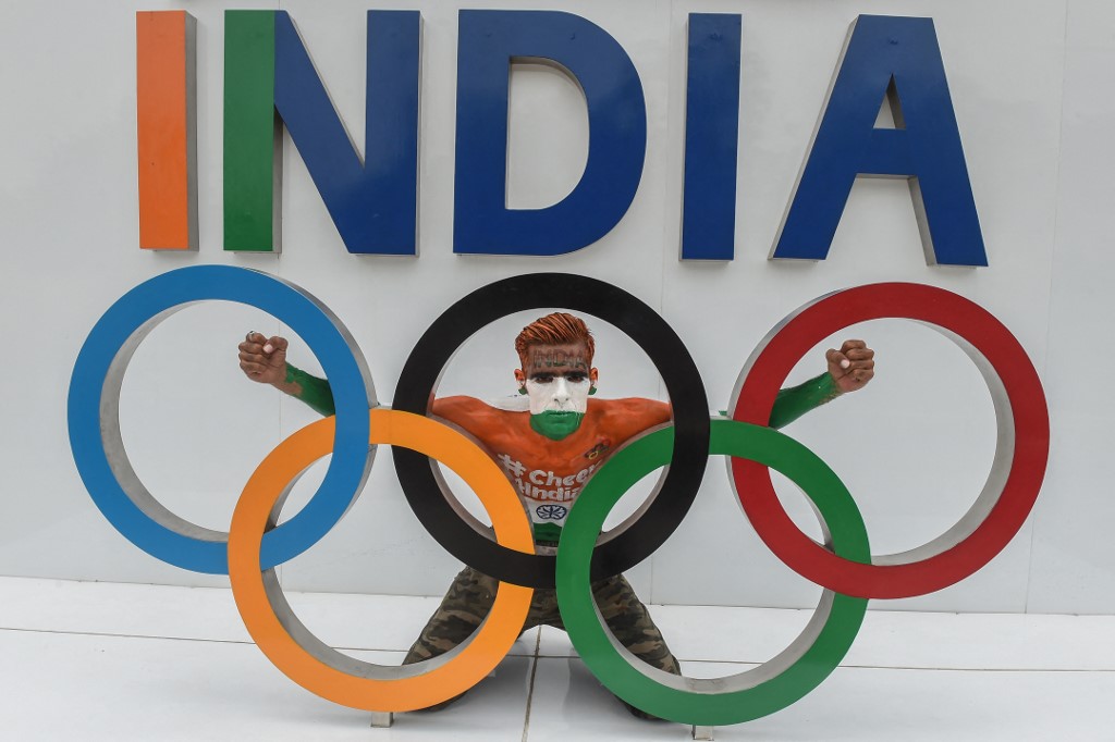 A sport enthusiast with his body painted in the colours of India's national flag poses for pictures as he shows support to the Indian athletes participating in the Tokyo Olympics 2020 in Ahmedabad on July 22, 2021