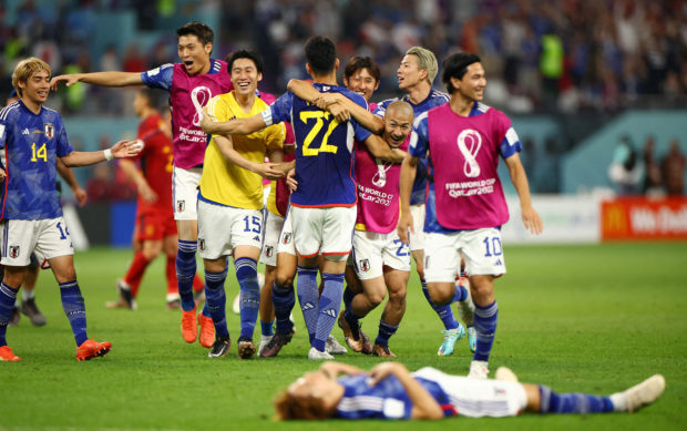 Soccer Football - FIFA World Cup Qatar 2022 - Group E - Japan v Spain - Khalifa International Stadium, Doha, Qatar - December 1, 2022 Japan's Maya Yoshida and Daizen Maeda celebrate with teammates after the match as Japan qualify for the knockout stages